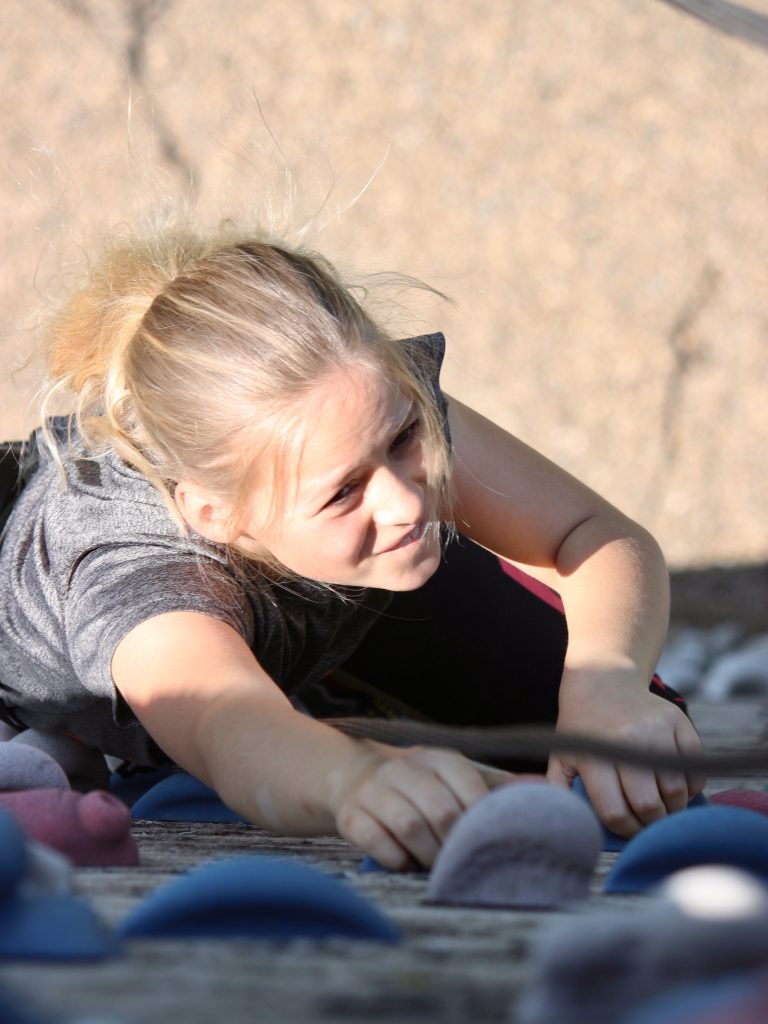 Ein Mädchen klettert am Seil bei den rockKIDS Kindertrainings